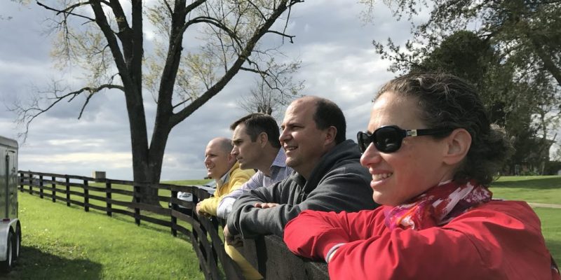 CLD Partners team members posing on fence on a ranch