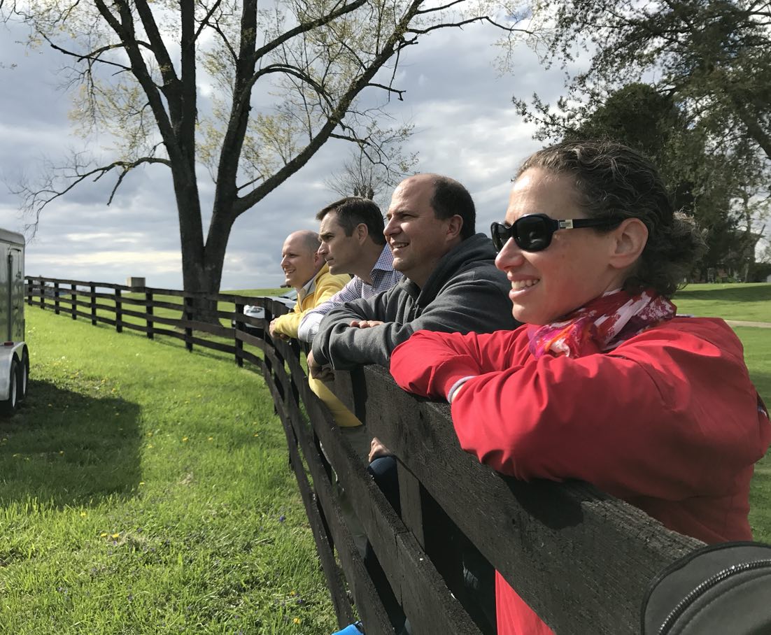 CLD Partners team members posing on fence on a ranch