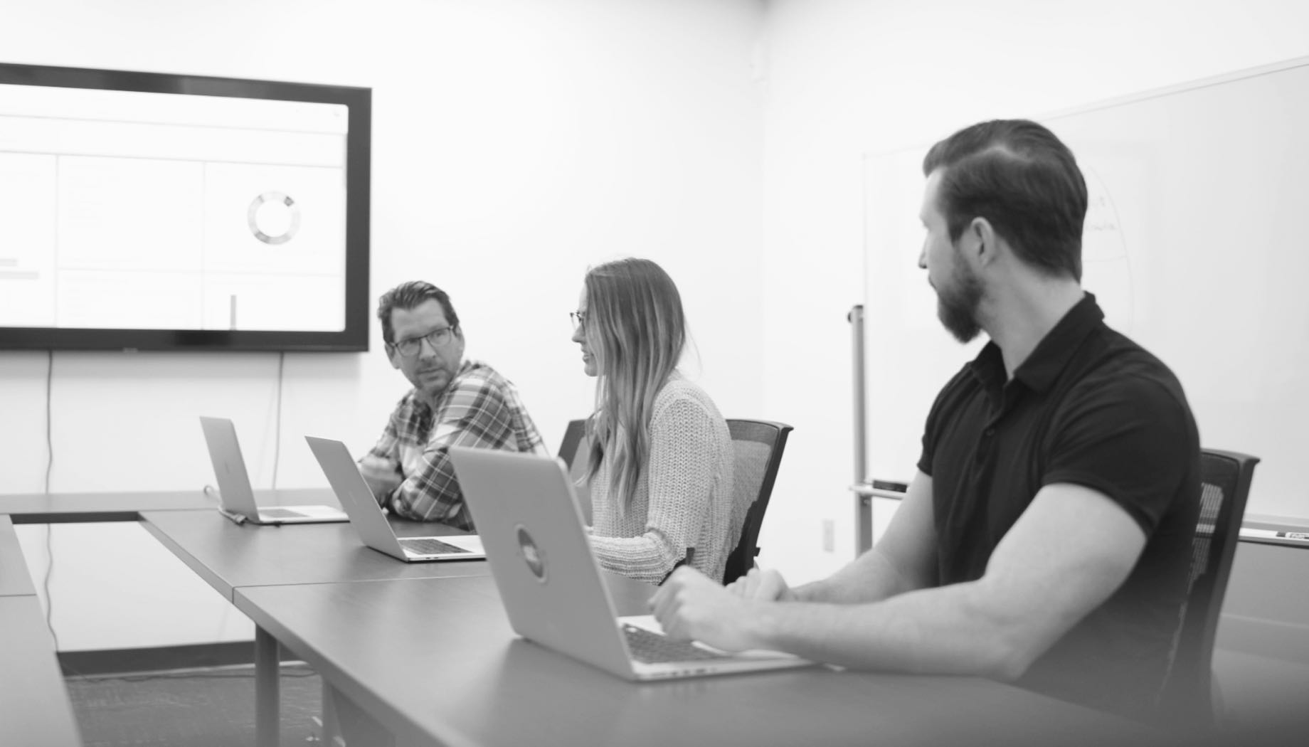 three people discussing business in conference room