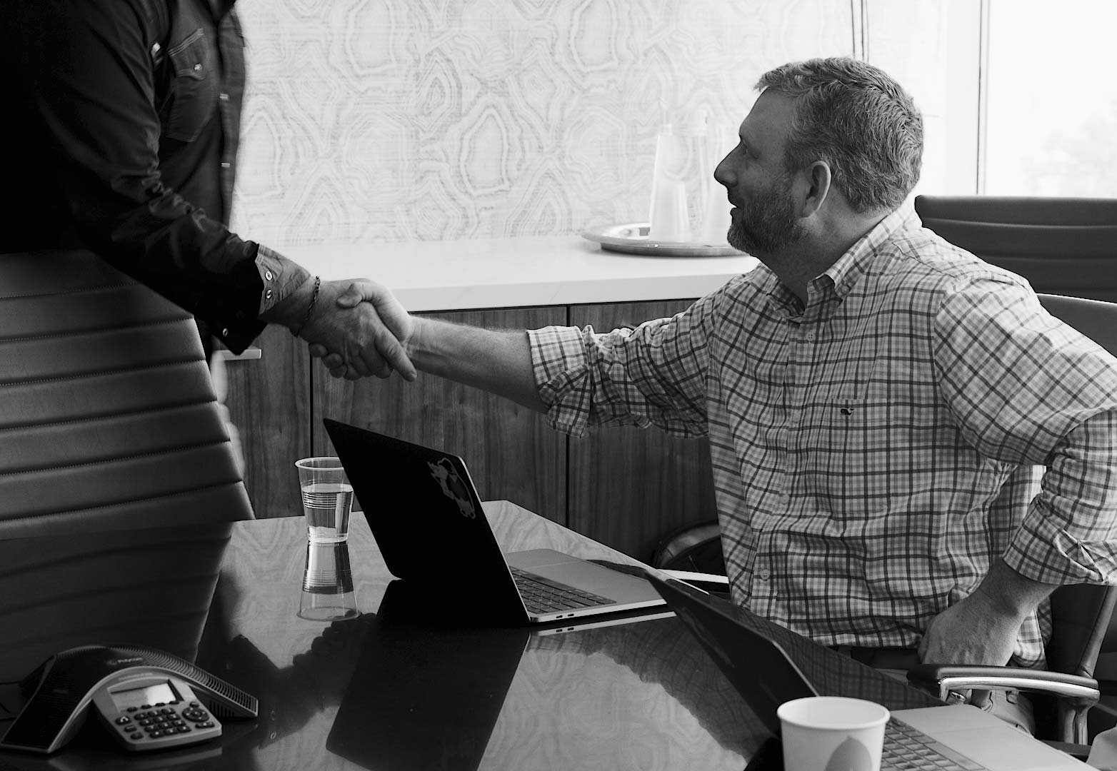 two men shaking hands at a meeting about financialforce implementation services