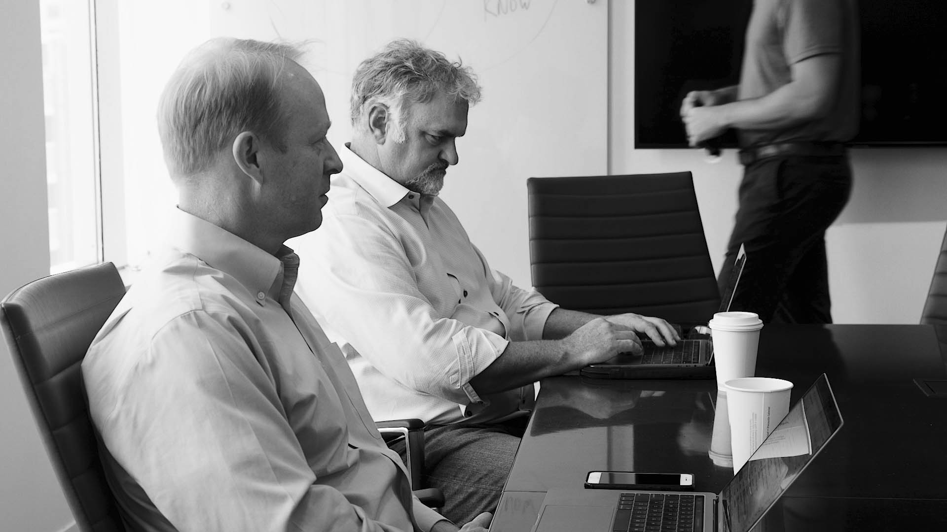 group of men meeting at a conference table about quote to cash solutions