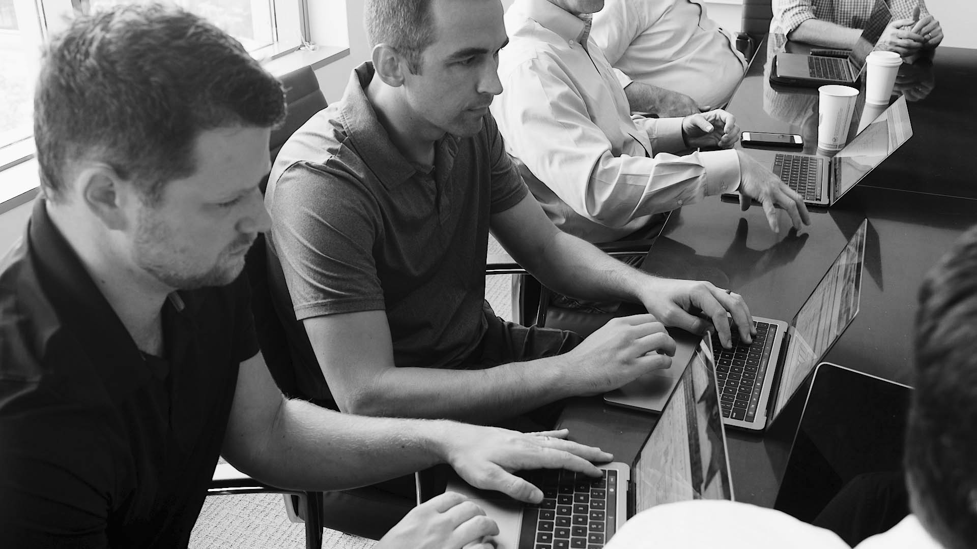 two FinancialForce services team members looking at their laptops