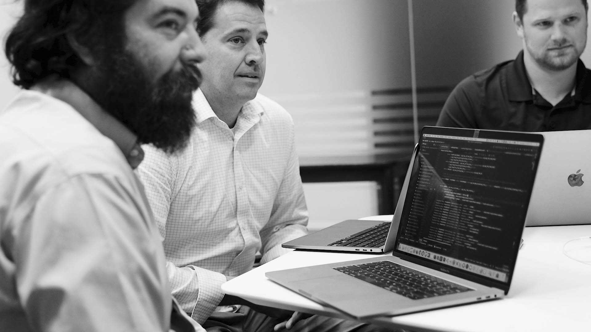 group of developers with FinancialForce implementation code on their laptops