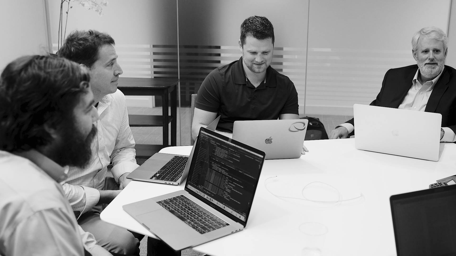 group of men meeting around a conference table discussing quote to cash consulting