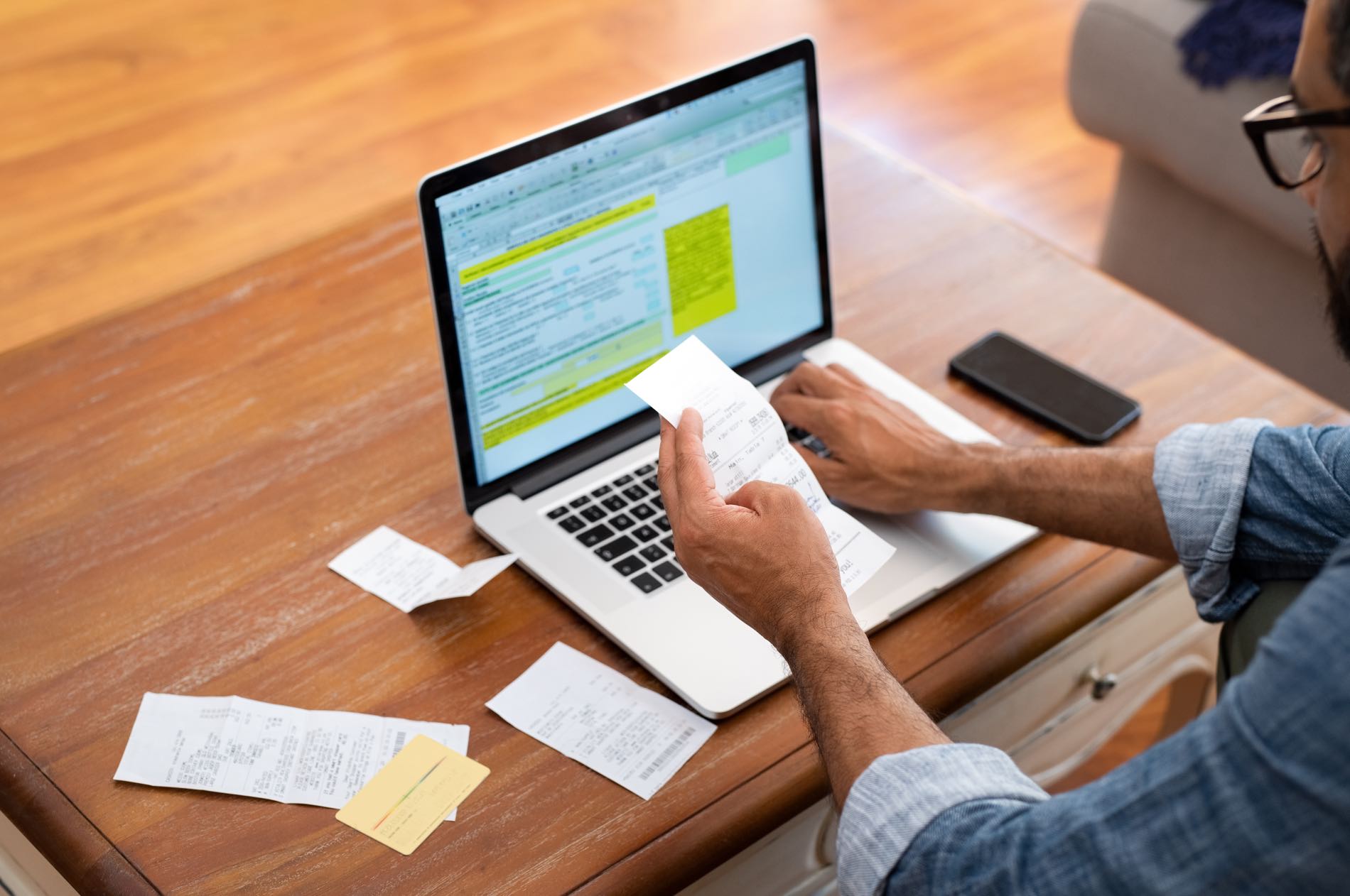 Man entering paper receipts into expense management system instead of using cld's concur and certinia integration solutions.